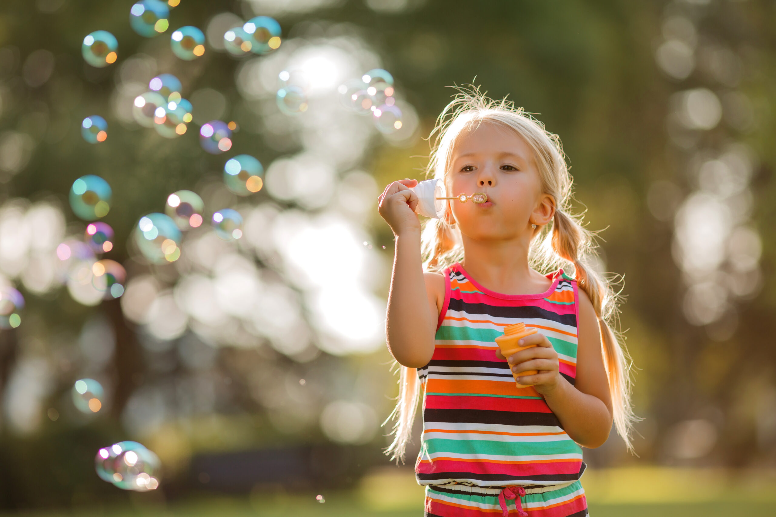 little-blonde-girl-inflates-soap-bubbles-summer-walk